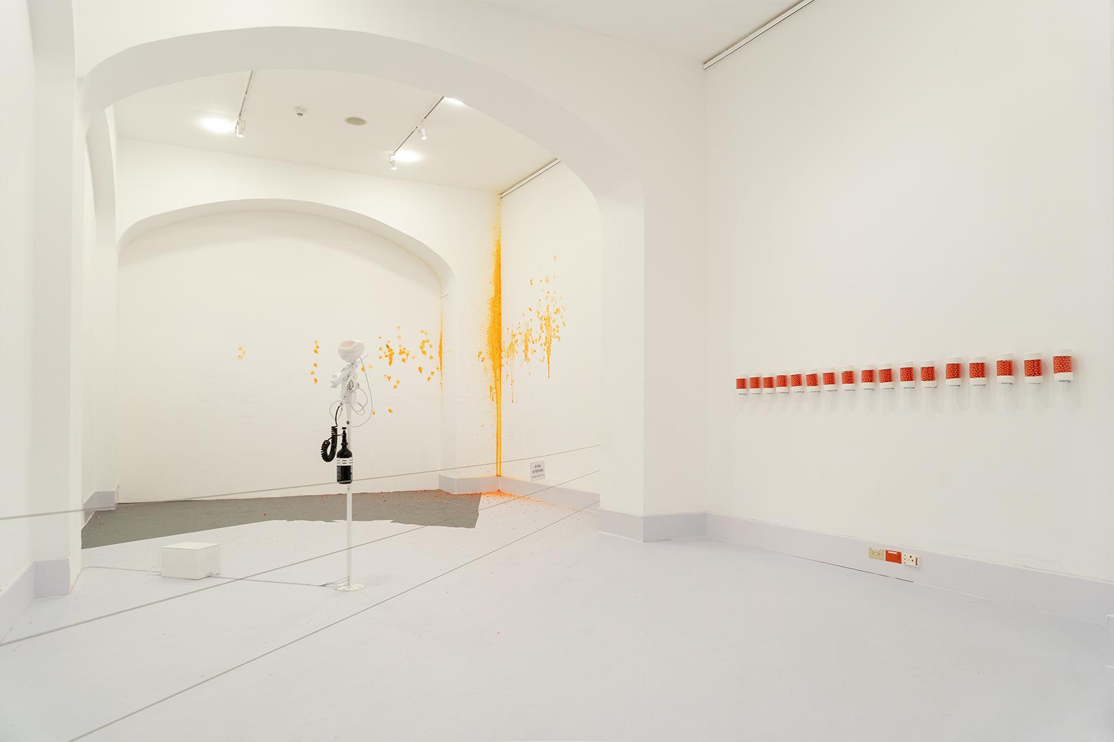 Installation view of The White House: robotic arm and orange-dot splatter
