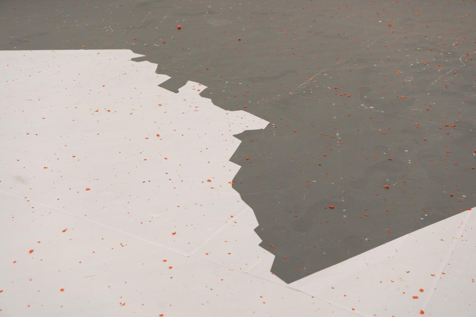 Orange dots scattered across a floor divided between white and grey